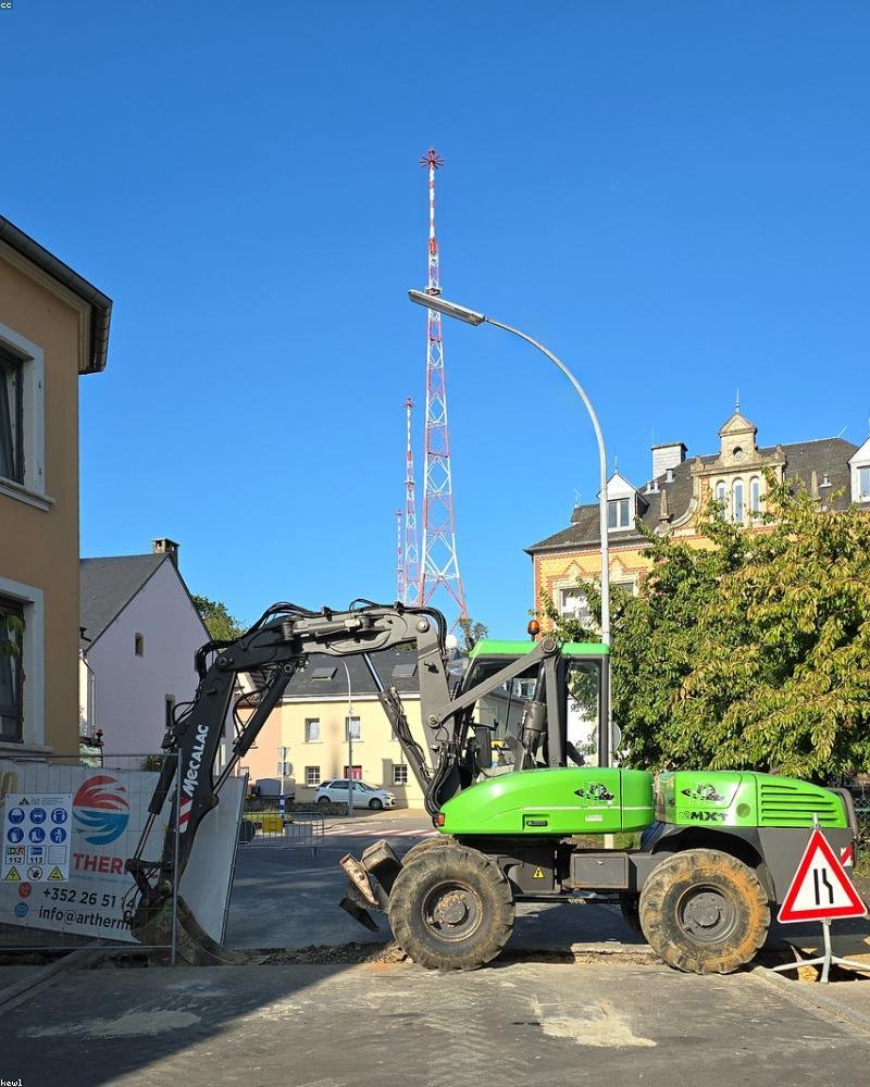 Excavator working on a residential street foundation dig — the kind of equipment used for Ottawa basement walkout projects